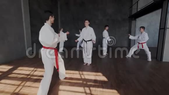 学校原武术跆拳道工艺穿着民族和服的青少年在跳跃时表现出强大的踢法视频的预览图