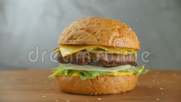 慢动作芝麻落在旋转汉堡上木制木板上的汉堡视频的预览图
