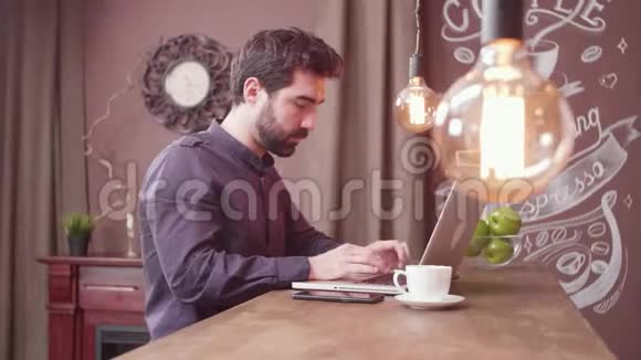年轻的自由职业者用他的智能手机在酒吧柜台付款视频的预览图