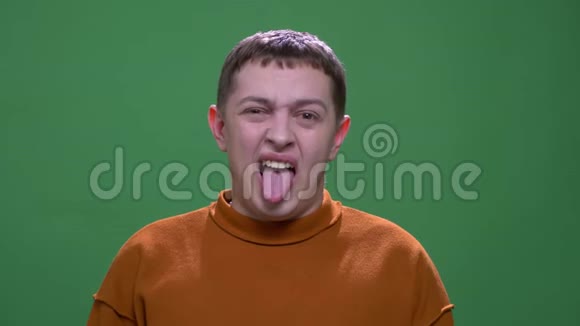 年轻有魅力的白种人男性特写镜头用舌头做滑稽的面部表情用相机看镜头视频的预览图