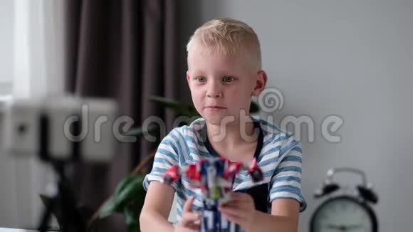 小男孩博主用相机手机录制视频并在家展示自己的玩具博客视频博客视频的预览图