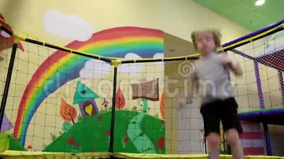 小男孩高兴地在操场上的蹦床上弹跳幼儿在接近终点时失败视频的预览图