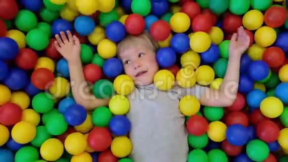 可爱的蹒跚学步的男孩孩子在儿童操场上玩五颜六色的球从阿博夫那里看到视频的预览图