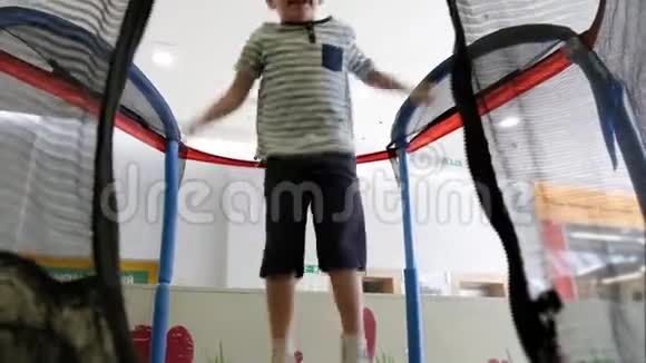 小男孩高兴地在操场上的蹦床上弹跳幼儿在接近终点时失败视频的预览图