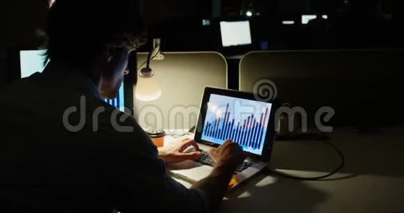 年轻的高加索男性高管在一间现代化办公室的办公桌上用笔记本电脑工作的后视镜视频的预览图