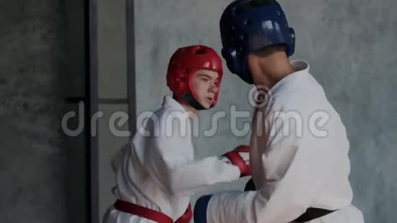 慢动作好斗的愤怒的拳击手打拳亚洲男孩对对手的脸做出强烈的极端踢视频的预览图