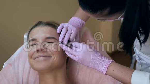 美丽的女人从美容师那里得到眼部美容注射清洁美容概念视频的预览图