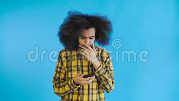 年轻悲伤的非裔美国人用电话在蓝色背景下得到坏消息情感概念视频的预览图