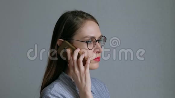 戴黑眼镜的女人在打电话后用头部按摩器放松视频的预览图