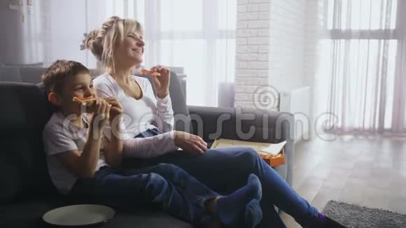 快乐的家庭看喜剧和吃零食视频的预览图