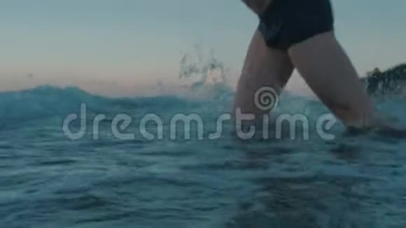 适合男人在日落时以慢动作跳跃海洋视频的预览图