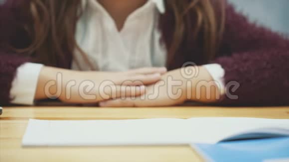在模糊的灰色背景上一个女学生的手紧紧地抓住举起一张有许多问号的纸视频的预览图