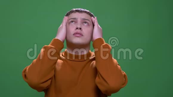 年轻有魅力的白种人男性的特写镜头头痛和疲劳背景被隔离在绿色上视频的预览图