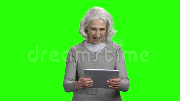 有趣的老年妇女在数字平板电脑上玩游戏视频的预览图