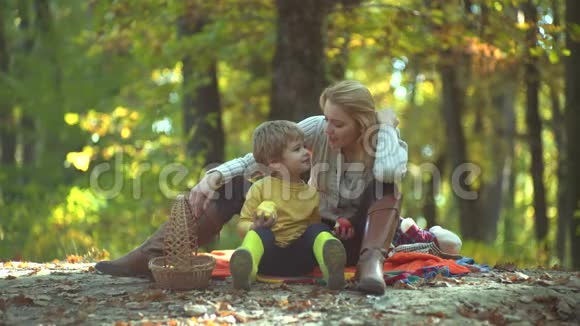 妈妈和儿子我们喜欢秋天的时光在一起时尚秋季家庭肖像自然背景视频的预览图