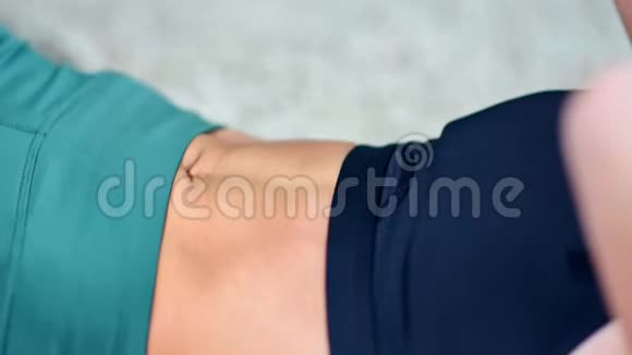 在腹肌训练侧视时女性肌肉腹部被晒黑视频的预览图