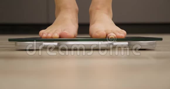 人类赤脚在厨房测量体重或超重体重秤上的女人减肥概念视频的预览图