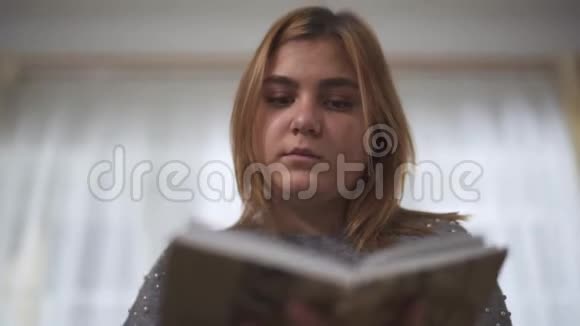 特写肖像加上大小女孩看书坐在家里的沙发上胖女人手里拿着书休闲视频的预览图
