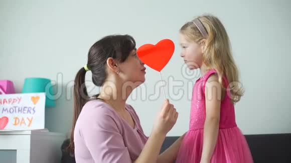 女孩和她妈妈抱着纸心接吻视频的预览图