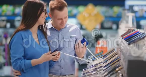 男人拿着智能手机指着女人手中的其他手机技术商店内部视频的预览图