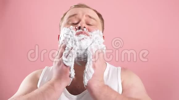 有趣的中年男子穿着t恤同时使用面部剃须泡沫动作缓慢视频的预览图
