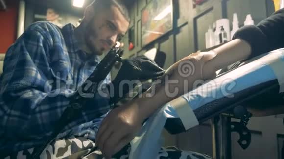 年轻人在假肢上工作纹身的过程视频的预览图