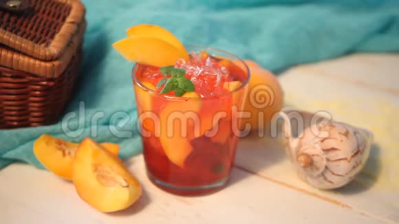 女人手放一杯新鲜的自制桃子甜冰茶或鸡尾酒柠檬水和薄荷清爽的冷饮夏季p视频的预览图