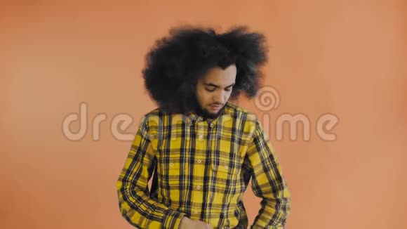 沮丧的年轻非洲裔美国男子持有破碎的手机橙色背景情感概念视频的预览图