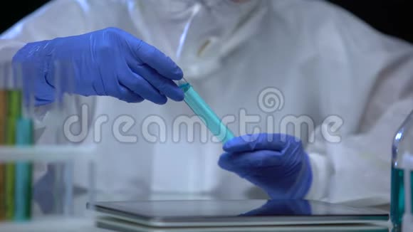 有毒的实验室工作人员检查有害液体并在片剂上做记录实验视频的预览图