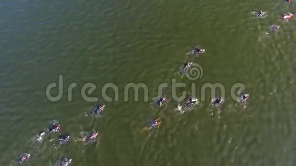 在水上竞赛中铁人三项选手从上到下穿越深绿色的河流视频的预览图