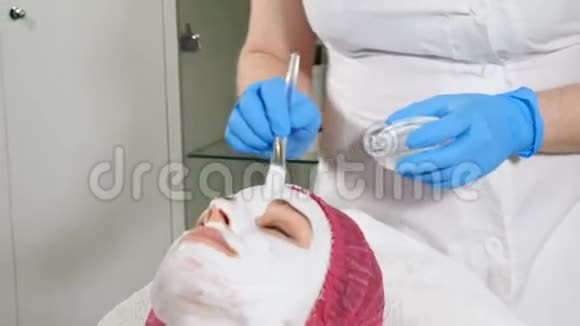 美容师将白色抗衰老面膜敷在脸上美的概念三十多岁的年轻女子在水疗中心视频的预览图