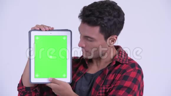 一位年轻快乐的西班牙裔时髦男人展示数码平板电脑视频的预览图