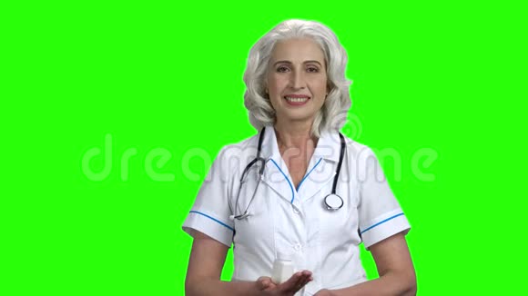 高级医生在绿色屏幕上展示药丸视频的预览图