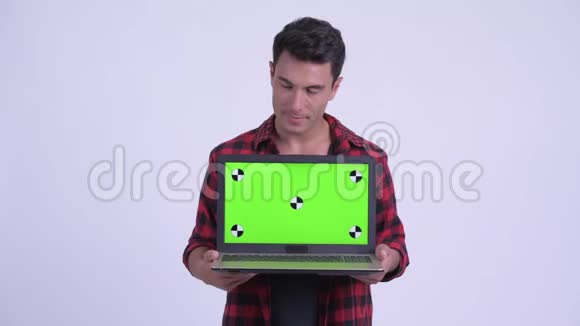 快乐的年轻西班牙裔时髦男人一边看笔记本电脑一边思考视频的预览图