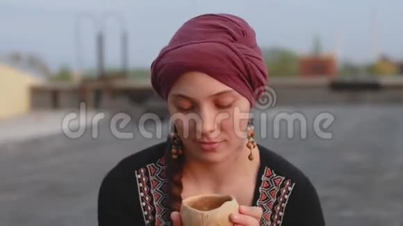 可爱的穆斯林女孩喝茶在外面微笑视频的预览图