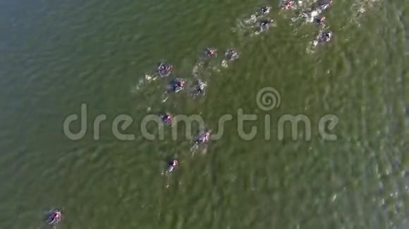 铁人三项赛手的空中自上而下绕过漂浮在水面上的红色浮标视频的预览图