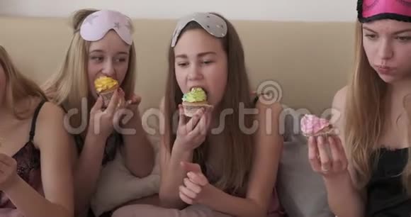 在睡衣派对期间看电影吃蛋糕的少女视频的预览图