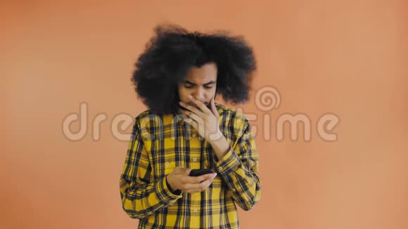 年轻悲伤的非裔美国人用电话在橙色背景下得到坏消息情感概念视频的预览图
