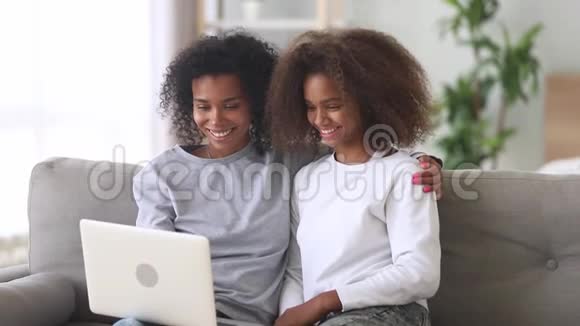 混血母女在家用笔记本电脑看电影视频的预览图