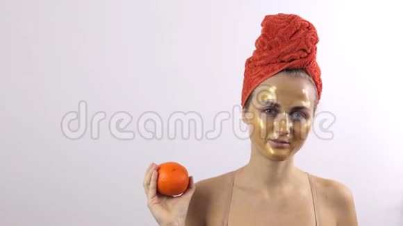 女孩的脸上戴着金色的面具而不是橙色的水果视频的预览图