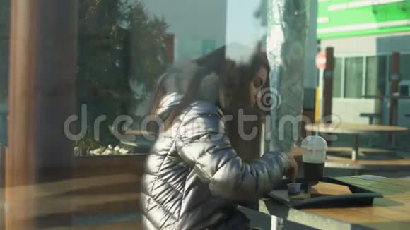 肮脏的无家可归的人手拿着餐厅的玻璃看着女人在自助餐厅吃饭视频的预览图