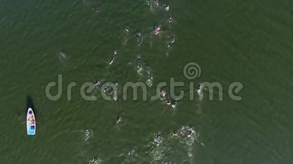 运动员在河上游泳比赛的高空向下附近有救生艇视频的预览图
