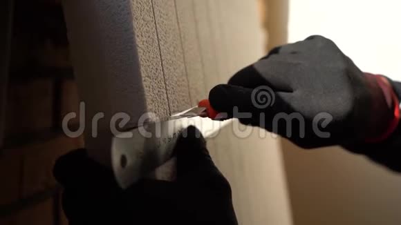 关闭手工人在黑色和红色手套使用金属标尺切割片的隔热灰色视频的预览图