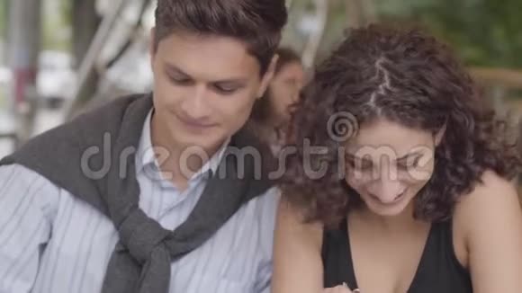 一对快乐的夫妇坐在户外的咖啡馆里吃沙漠年轻男女坐在一起享受视频的预览图