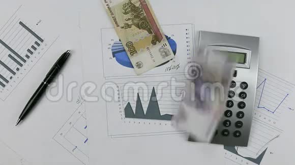 用计算器和钢笔把卢布涂在图表上把钱扔到桌子上视频的预览图