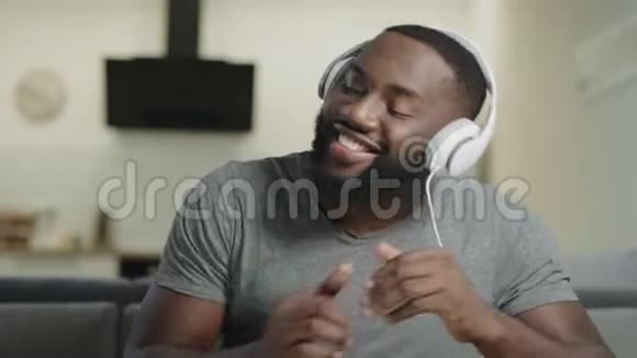 用耳机唱歌的男性肖像快乐的成人听音乐视频的预览图