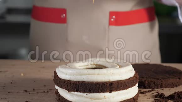 糕点厨师正在把焦糖倒在巧克力海绵蛋糕上在面包店做蛋糕视频的预览图