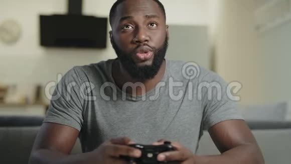 黑人在家玩电子游戏一幅黑人男子手持游戏台的肖像视频的预览图