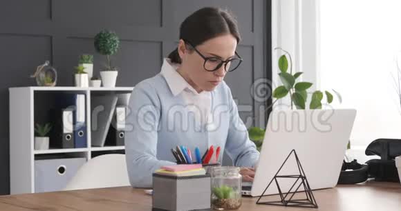 兴奋的女商人在笔记本电脑上工作时收到好消息视频的预览图