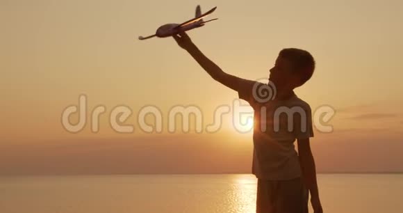 快乐的孩子在日落背景下带着玩具飞机跑步童年的梦想视频的预览图